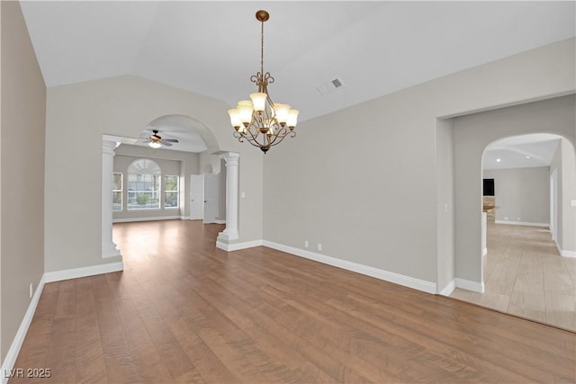 2595 Aviv Ct, Las Vegas, NV 89121 - unfurnished room featuring arched walkways, a ceiling fan, wood finished floors, a chandelier, and vaulted ceiling
