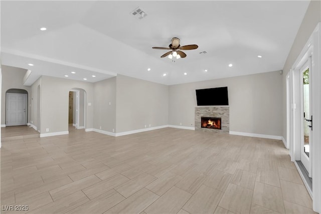 2595 Aviv Ct, Las Vegas, NV 89121 - unfurnished living room featuring recessed lighting, a warm lit fireplace, a ceiling fan, visible vents, and arched walkways