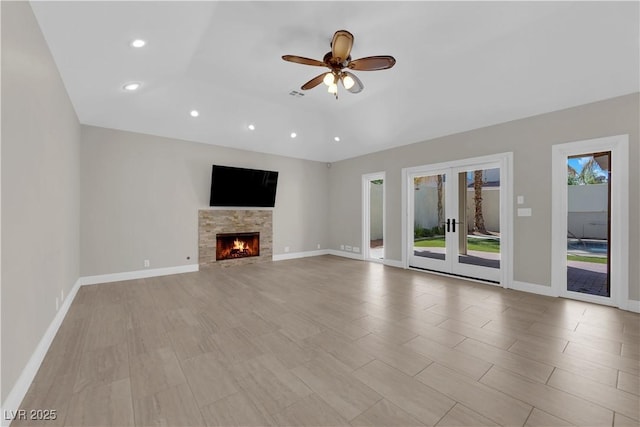 2595 Aviv Ct, Las Vegas, NV 89121 - unfurnished living room featuring recessed lighting, ceiling fan, a lit fireplace, baseboards, and french doors