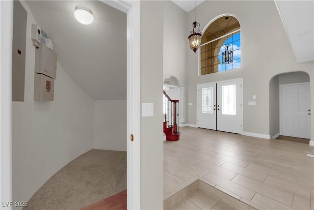 2595 Aviv Ct, Las Vegas, NV 89121 - entrance foyer featuring stairway, a chandelier, a towering ceiling, arched walkways, and wood finished floors