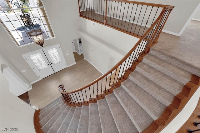 2595 Aviv Ct, Las Vegas, NV 89121 - stairway with a high ceiling, an inviting chandelier, visible vents, baseboards, and french doors