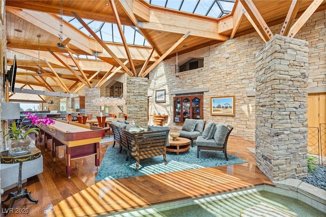 game room with beamed ceiling, high vaulted ceiling, wood ceiling, a skylight, and hardwood / wood-style floors