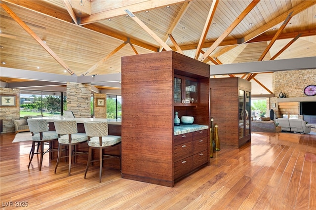 kitchen with beamed ceiling, light wood finished floors, high vaulted ceiling, wood ceiling, and open floor plan
