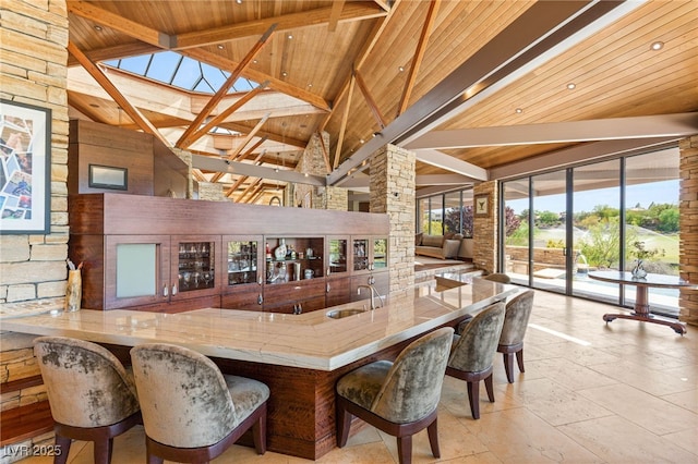 bar featuring indoor wet bar, a sink, beam ceiling, high vaulted ceiling, and wood ceiling
