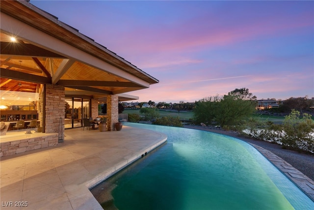 view of swimming pool with a patio area and an infinity pool