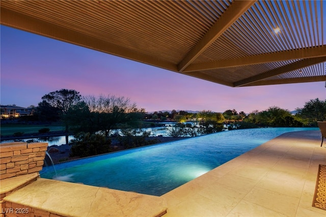 view of swimming pool with a patio, a water view, and an infinity pool