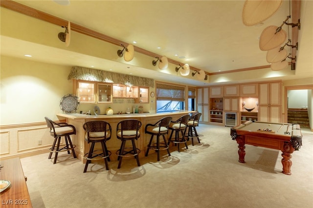 bar featuring a wainscoted wall, light carpet, indoor wet bar, pool table, and a decorative wall