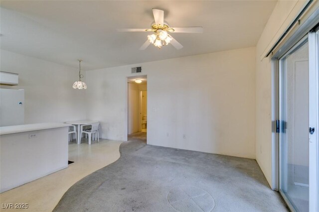 unfurnished living room featuring visible vents, ceiling fan, and carpet floors
