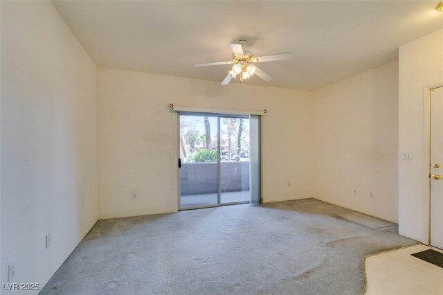 empty room featuring ceiling fan and light carpet