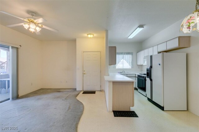 kitchen with ceiling fan, range with gas cooktop, light countertops, a sink, and white fridge with ice dispenser