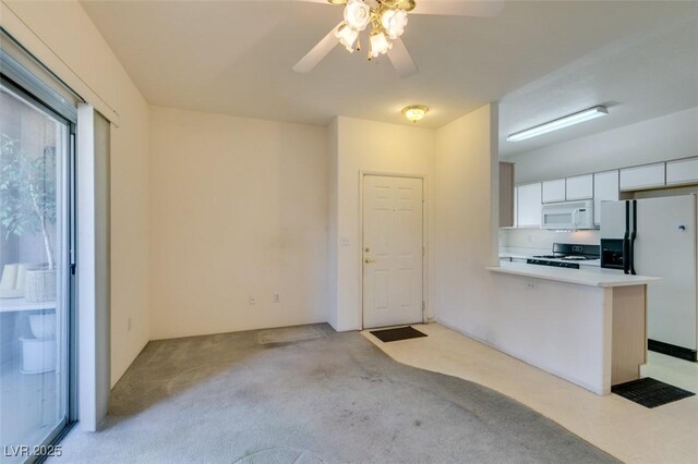 5751 E Hacienda Ave Unit 105, Las Vegas, NV 89122 - kitchen with white appliances, white cabinets, ceiling fan, light countertops, and light carpet
