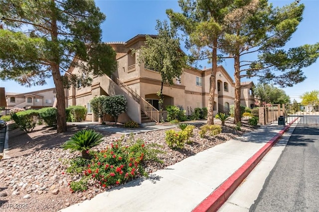 view of property featuring stairway, fence, and a residential view