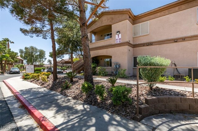 5751 E Hacienda Ave Unit 105, Las Vegas, NV 89122 - view of building exterior with central AC and stairs