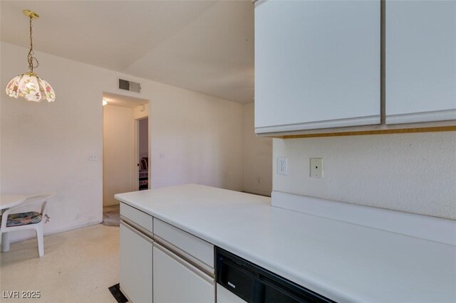 kitchen featuring visible vents, light countertops, white cabinetry, and decorative light fixtures