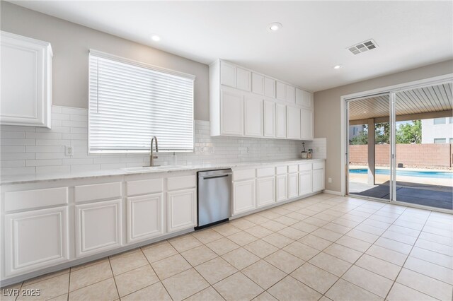 kitchen featuring backsplash, visible vents, a sink, and dishwasher