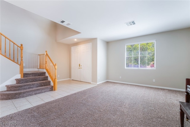 unfurnished living room featuring visible vents, carpet, and stairs