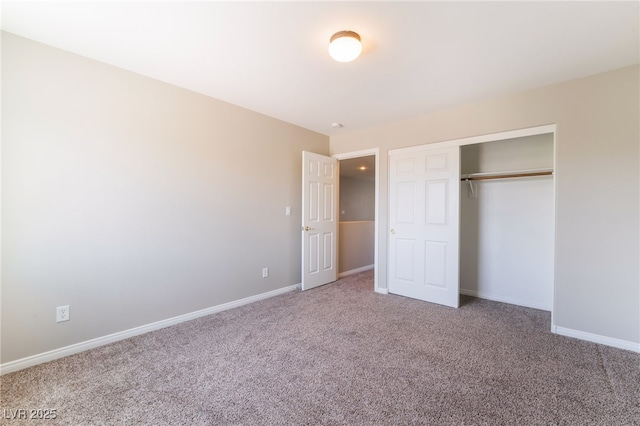 unfurnished bedroom with carpet floors, baseboards, and a closet