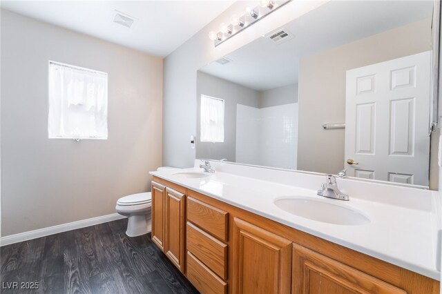 full bath with toilet, visible vents, and a sink