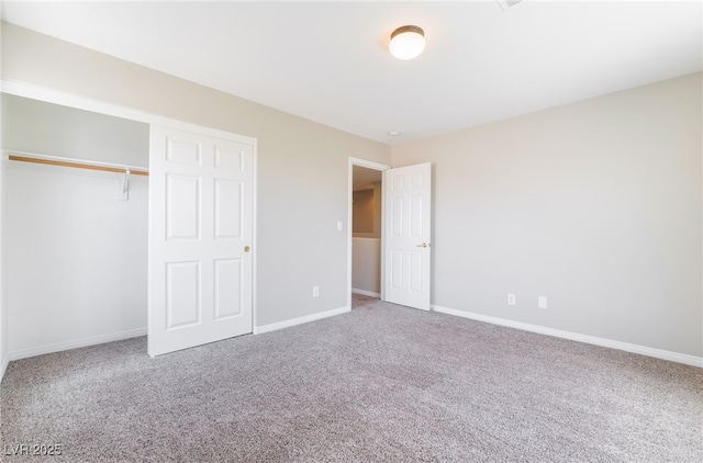 unfurnished bedroom featuring baseboards, carpet, and a closet
