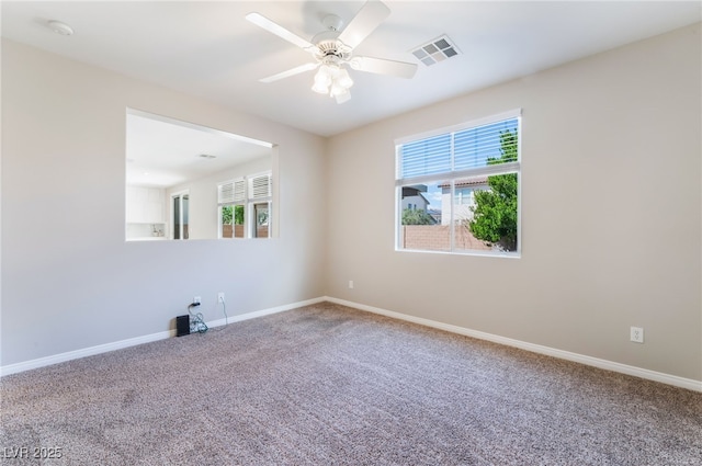 empty room featuring carpet floors, baseboards, visible vents, and ceiling fan