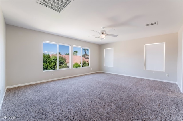 spare room with visible vents, carpet flooring, and ceiling fan
