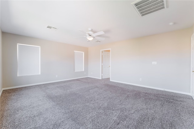 carpeted spare room featuring baseboards, ceiling fan, and visible vents