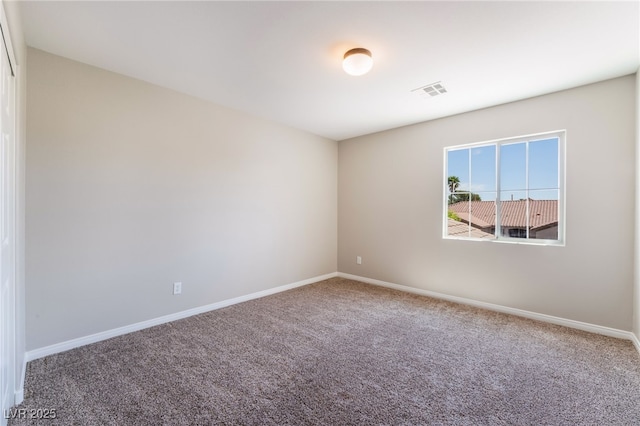 unfurnished room with baseboards, carpet, and visible vents