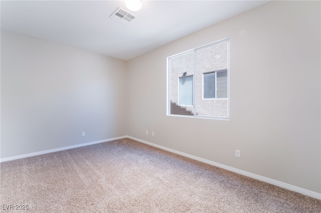 spare room featuring carpet floors, baseboards, and visible vents