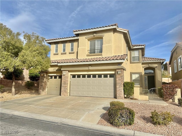 mediterranean / spanish home featuring stucco siding, concrete driveway, a tile roof, and a garage
