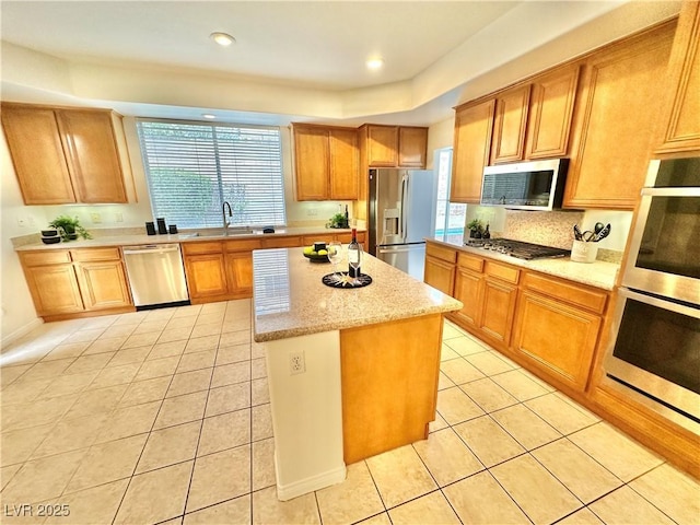 kitchen with a center island, stainless steel appliances, light tile patterned flooring, and a wealth of natural light