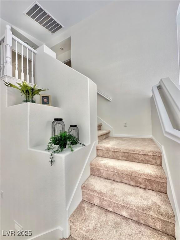 stairway featuring carpet floors and visible vents