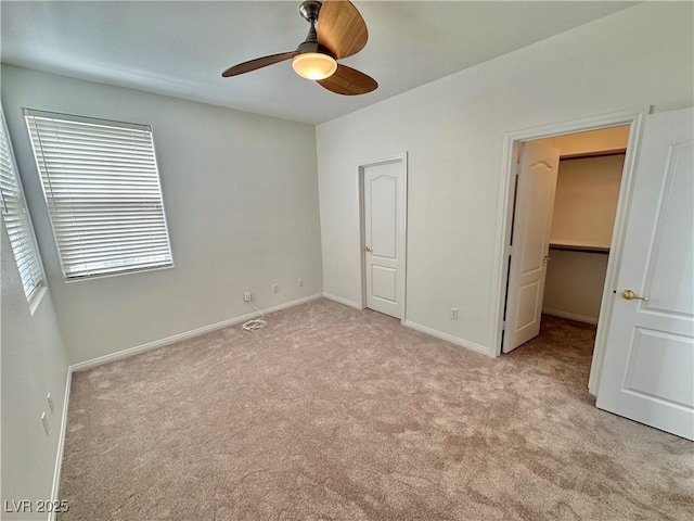 unfurnished bedroom with baseboards, light colored carpet, ceiling fan, and a closet