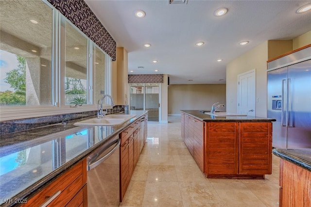 kitchen featuring brown cabinets, a sink, and appliances with stainless steel finishes
