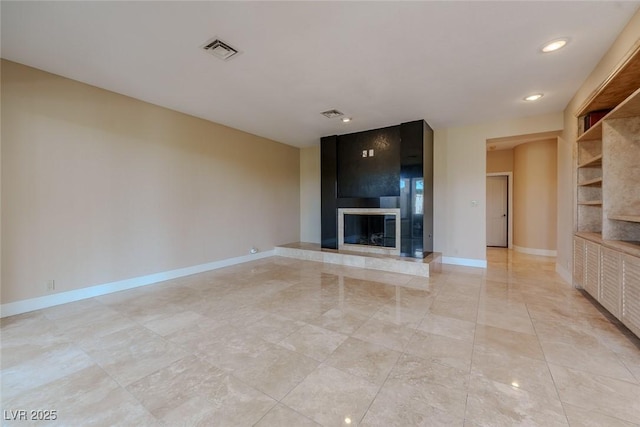 unfurnished living room featuring visible vents, baseboards, recessed lighting, a fireplace, and built in shelves