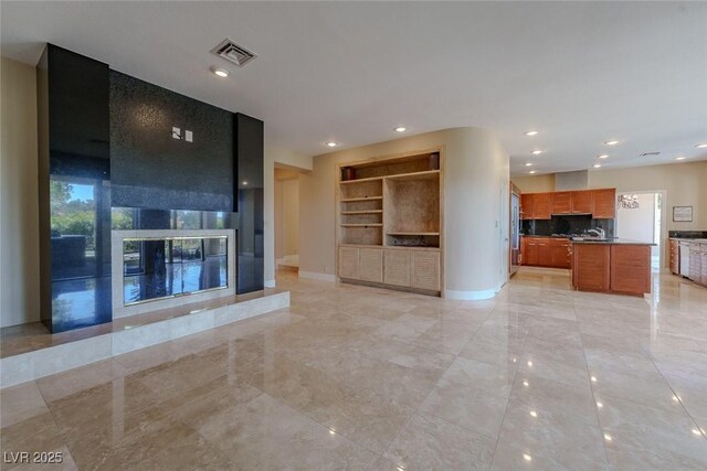 unfurnished living room featuring recessed lighting, a tile fireplace, built in features, visible vents, and baseboards