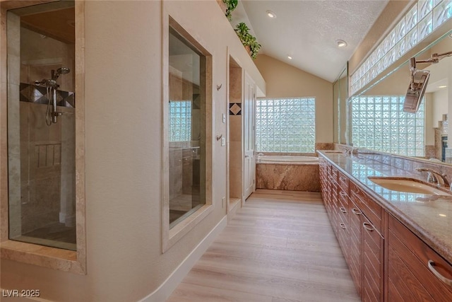 full bath with a stall shower, wood finished floors, lofted ceiling, and vanity