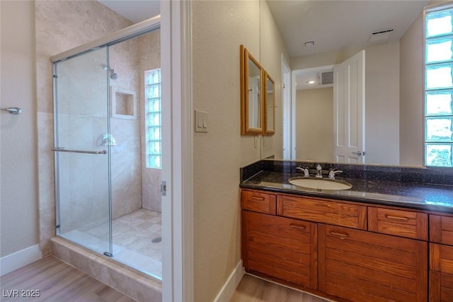 bathroom with visible vents, a stall shower, wood finished floors, and vanity