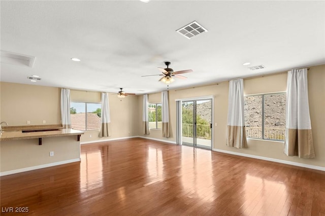 17 Morninglow Pass, Henderson, NV 89052 - unfurnished living room featuring baseboards, visible vents, wood finished floors, and ceiling fan