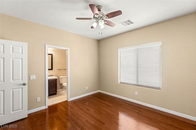 17 Morninglow Pass, Henderson, NV 89052 - unfurnished bedroom featuring a ceiling fan, visible vents, baseboards, wood finished floors, and ensuite bathroom