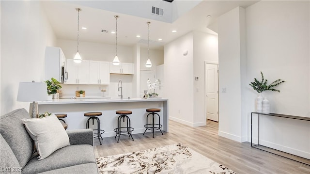 1187 Blossom Point St Unit 36, Las Vegas, NV 89135 - kitchen featuring a breakfast bar, light countertops, visible vents, a peninsula, and a towering ceiling