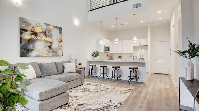 1187 Blossom Point St Unit 36, Las Vegas, NV 89135 - living room featuring visible vents, a high ceiling, light wood-style flooring, and recessed lighting