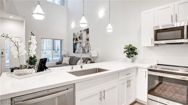 1187 Blossom Point St Unit 36, Las Vegas, NV 89135 - kitchen featuring white cabinetry, a sink, appliances with stainless steel finishes, light countertops, and a high ceiling