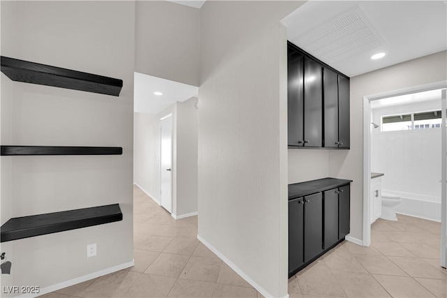 corridor with recessed lighting, light tile patterned flooring, and baseboards