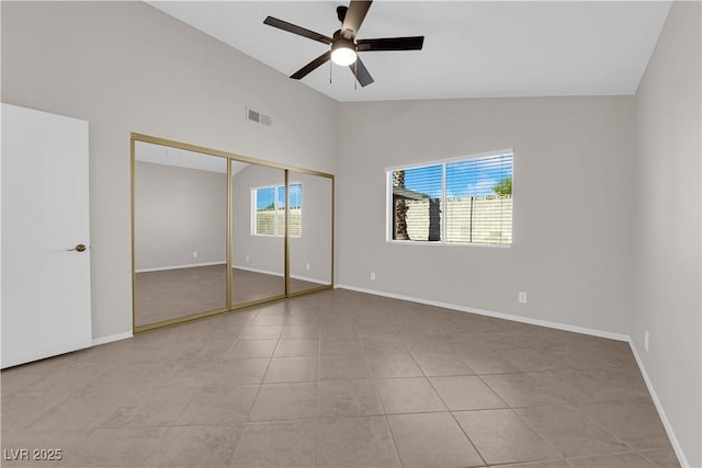 unfurnished bedroom with tile patterned flooring, baseboards, visible vents, a ceiling fan, and high vaulted ceiling