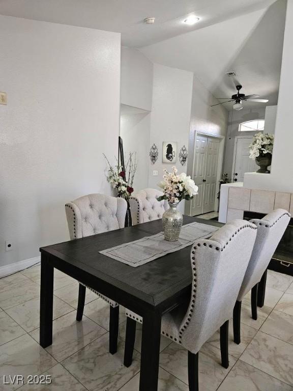 dining room with marble finish floor, ceiling fan, high vaulted ceiling, and baseboards
