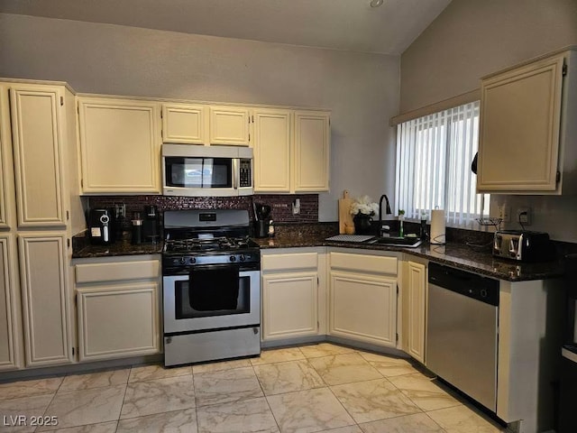 kitchen with tasteful backsplash, dark stone counters, stainless steel appliances, marble finish floor, and a sink