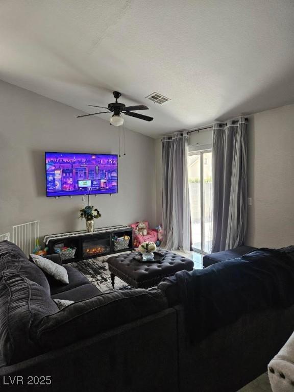 living area featuring visible vents and ceiling fan
