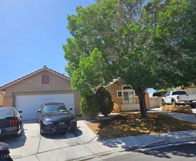 view of front of home with a garage, stucco siding, and driveway