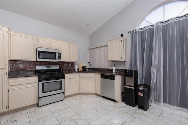 2631 Bed Knoll Ct, North Las Vegas, NV 89031 - kitchen with appliances with stainless steel finishes, light marble finish flooring, backsplash, dark stone countertops, and high vaulted ceiling