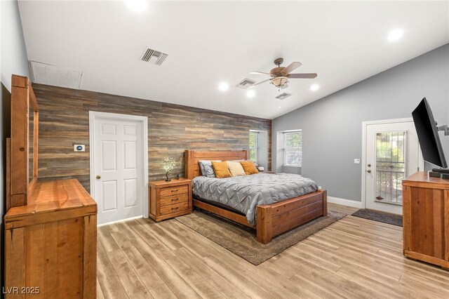 bedroom featuring lofted ceiling, an accent wall, visible vents, and access to exterior
